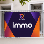 Panneaux alvéolaires accrochés sur un balcon pour la publicité d’une agence immobilière.